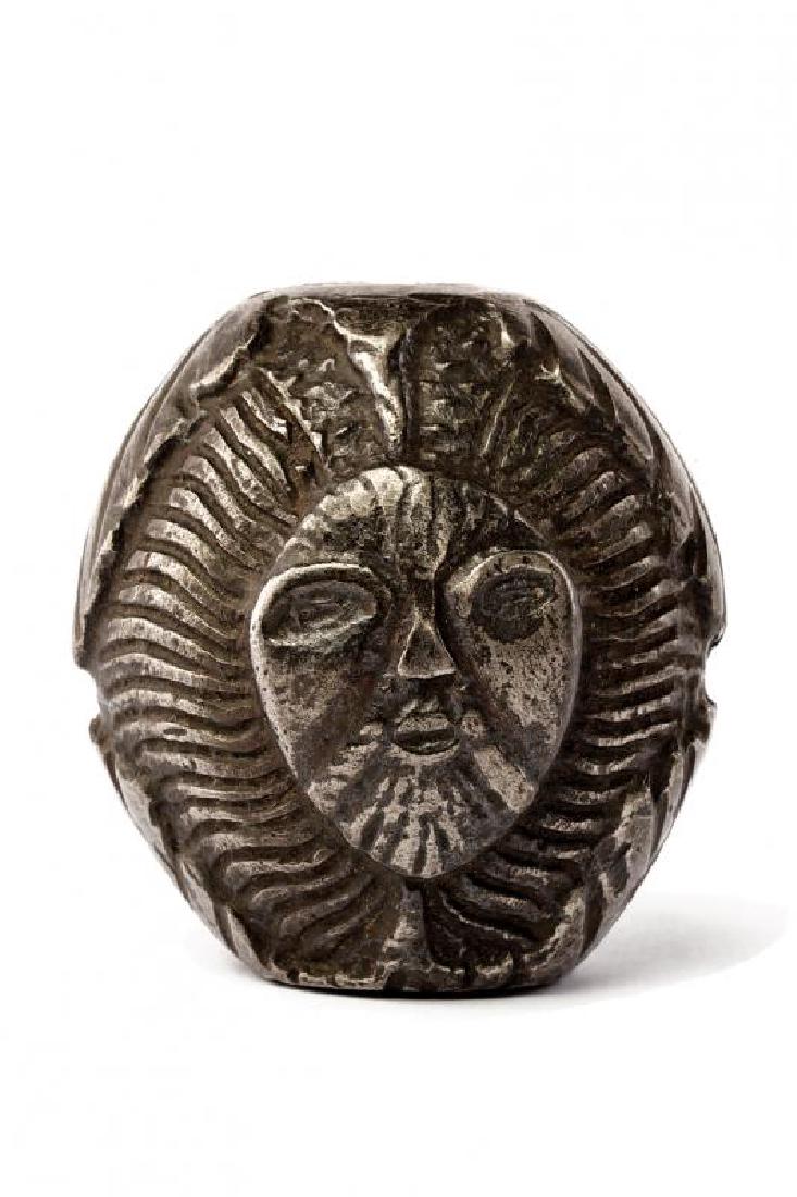 A fine sword pommel: dating: 16th Century provenance: Germany, In iron, chiselled with two faces divided by foliage in high-relief. height 5.2 cm.