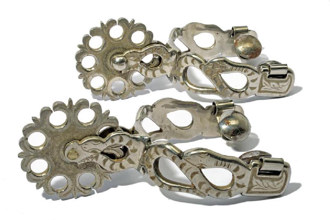 A pair of spurs: dating: 20th Century provenance: Mexico, In iron, with pierced heel bands, engraved with a snake, neck decorated en suite, pierced and engraved rowels. length 17 cm.