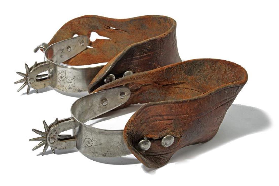 A pair of spurs: dating: 20th Century provenance: USA, In iron, with wide heel bands engraved with stars, shaped as horseshoe, with star-rowel with ten tips. A spur with a riveted hook (the hook helped the cowboy to r