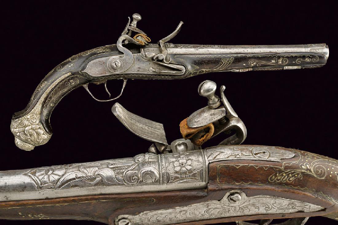 A fine flintlock pistol: dating: first quarter of the 19th Century provenance: Turkey, Smooth, 15 mm cal. barrel, carved at the base with high-relieved trophies and floral motifs, nozzle with a figure; tang carved en suite; i