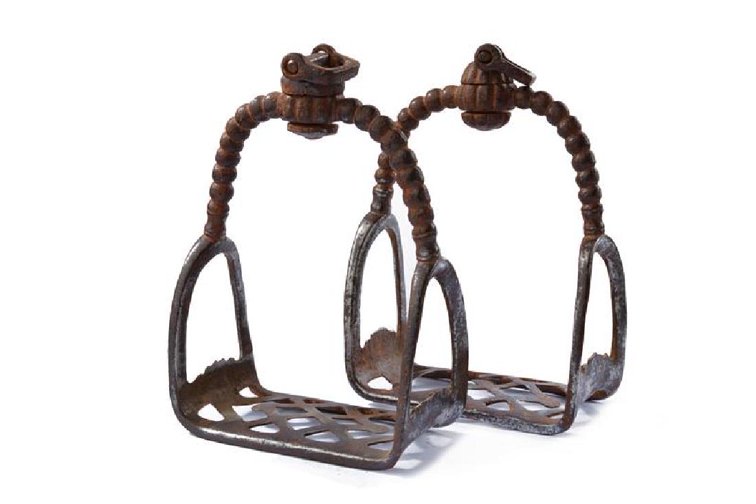 A rare pair of stirrups: dating: 17th Century provenance: China, In iron. Wide, rectangular, pierced treads (part missing on one stirrup), beaded external bands, movable loops on a pumpkin-shaped base. Ming Dynasty. height 20