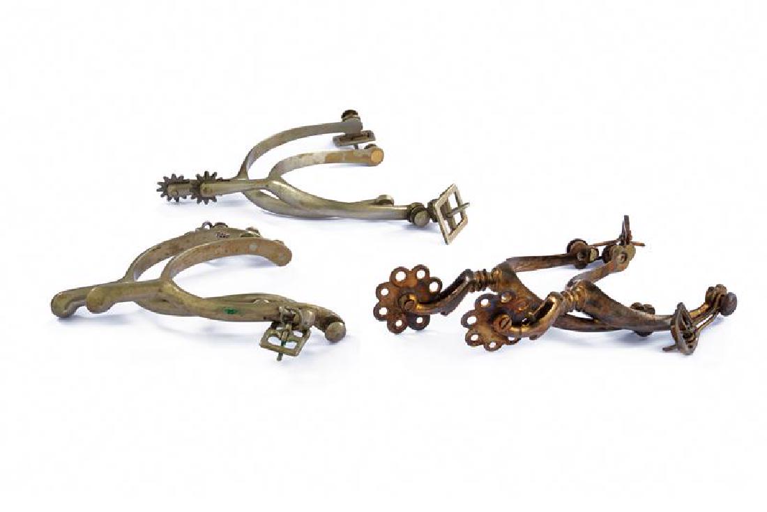 A lot of three pairs of spurs: dating: first quarter of the 20th Century provenance: USA, A pair by August Buermann, experimental model 1914, marked 'A. B. US' and 'Solid Nickel', and two other pairs of spurs. length 13.5 - 15.5 cm
