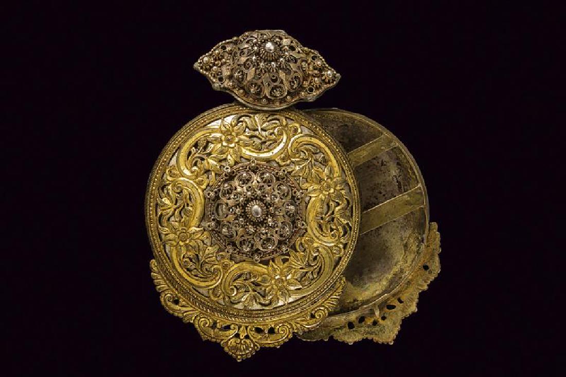 A big silver mounted buckle: dating: Late 19th Century provenance: Greece, Composed of two, big, circular, silver elements, loaded with a silver, gilded plate, pierced with spirals and flowers and both provided with a stud in the