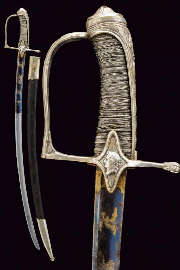 A Jeune guard sabre: dating: First Empire provenance: France, Curved, single-and short false-edged blade with large, central fuller, first part engraved and gilded on a blue ground with trophies and floral motifs; silver,