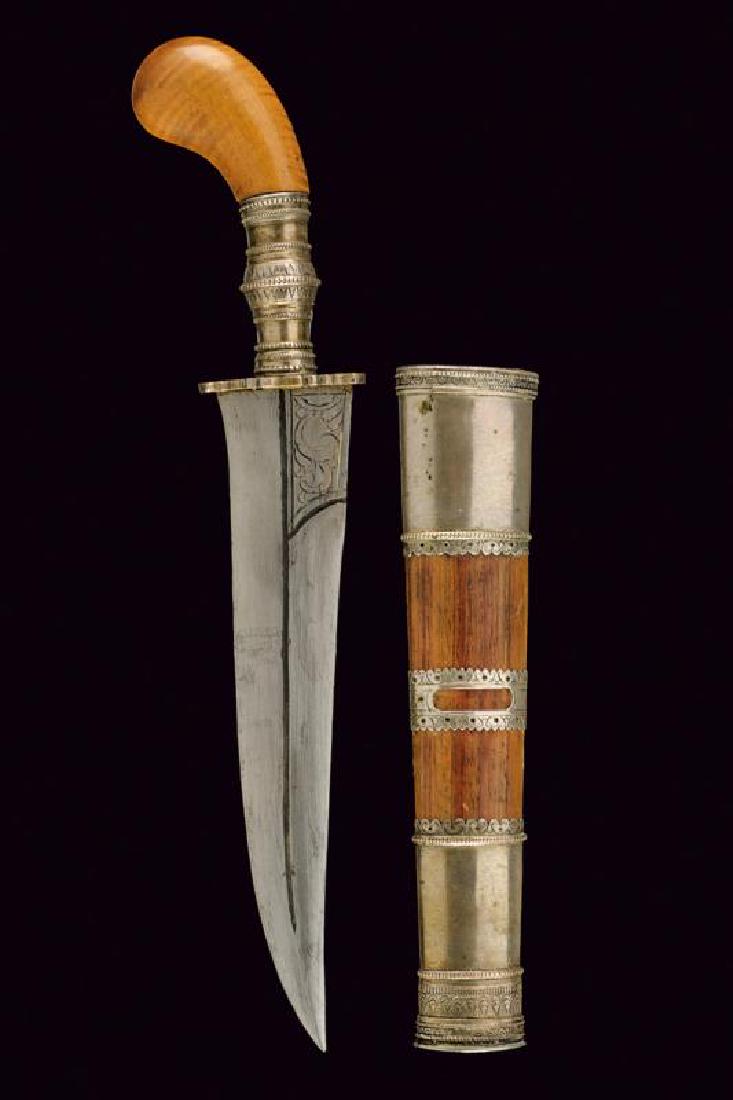 A dagger: dating: Late 19th Century provenance: Indonesia, Slightly curved, single-and false-edged blade, ribbed in the center and grooved, with short segment, engraved with floral motifs at the base. Silver-co