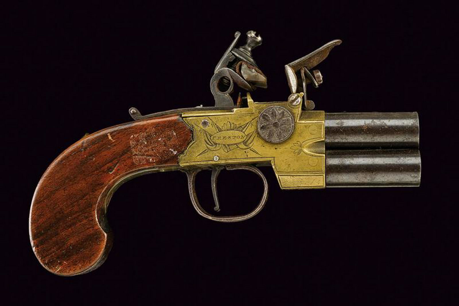 An over and under barreled flintlock pocket pistol by: dating: Early 19th Century provenance: England, Round, smooth-bore, finished, 9 mm cal. barrels; brass frame, engraved with trophies and floral motifs, signed 'Edw.d Jolley' and 'Preston', incomplete 