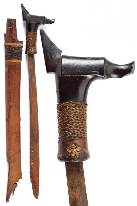 Mandau: dating: early 20th Century provenance: Kalimantan, Blade of typical shape, slightly decorated with carvings on the back and dots on one side of the blade, some brass-inlaid, surface rust. Ebony grip,