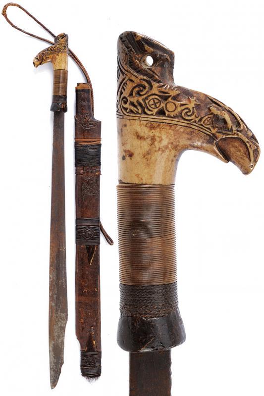 Mandau: dating: Late 19th Century provenance: Kalimantan, Single-edged blade, of typical shape, slightly chiselled at the base. Bone grip, embossed, base covered with vegetable and metallic wire binding. Wood