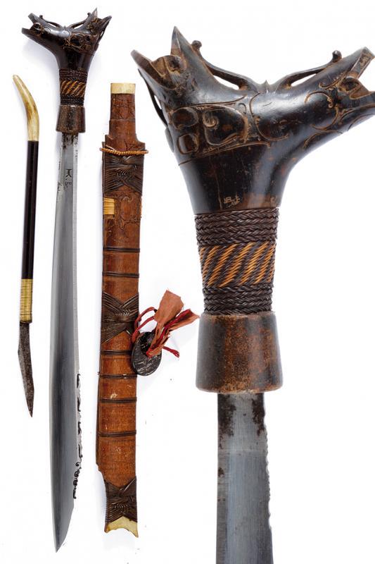 Mandau: dating: early 20th Century provenance: Kalimantan, Single-edged blade of typical shape, chiselled back, base with two stamps. Wooden hilt, embossed, base covered with vegetable wire binding. Wooden sc