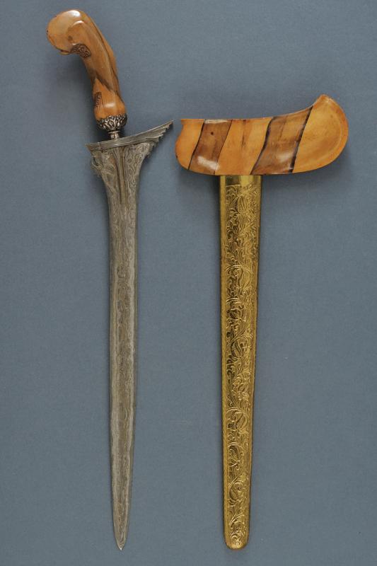 A kris: dating: provenance: Giava, Straight, smooth double-edged blade, in fine pamor, with grooved and chiselled base. Wooden ukiran, slightly embossed with floral motifs, white metal, engraved selut. Wooden