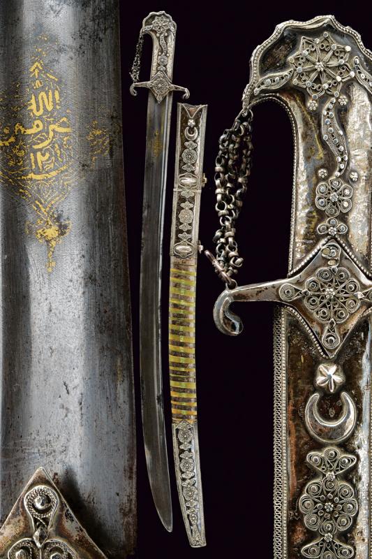 A silver mounted saif: dating: 19th Century provenance: Arabia, Wide, curved, single-and short false-edged blade, with a large, central fuller and one more thin next to the back, with remains of cartouche on both facets at 
