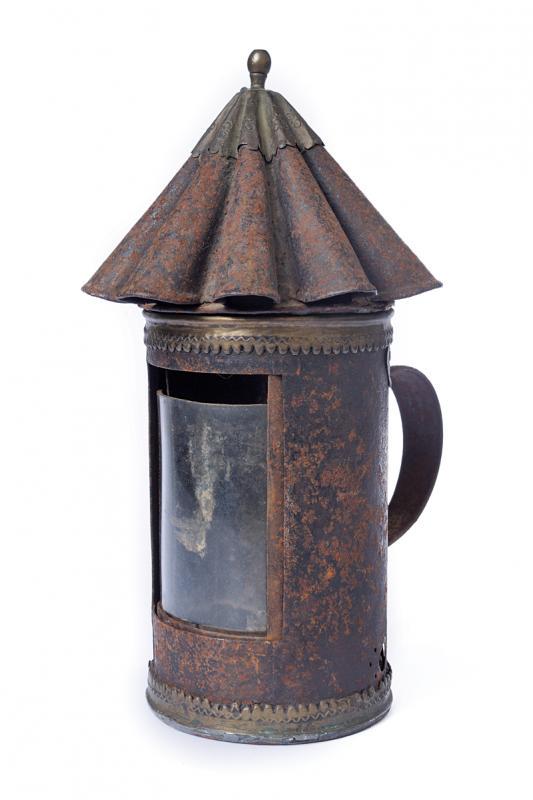 A patrol lantern: dating: 18th Century provenance: Italy, Cylindrical, iron with glass inside and foil for shielding (to be unblocked). Cover of cusped and undulated shape, with peak in brass foil with small, floral de