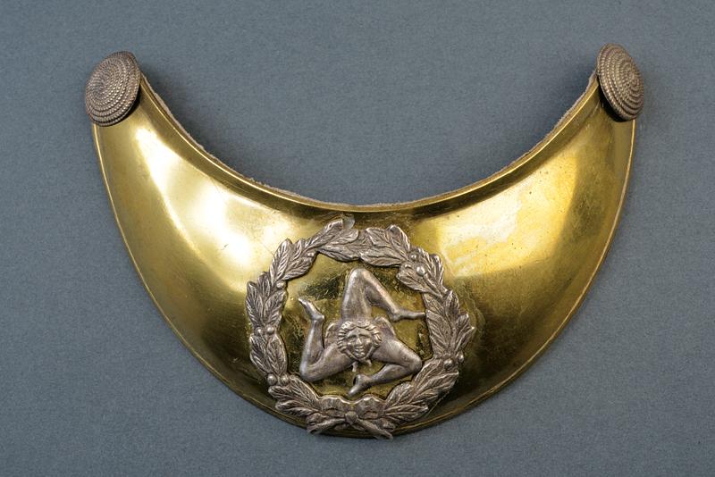 an officier gorget: dating: 1848 - 1849 provenance: Interim Goverment of Sicily, In brass, with silver buttons. Back part lined with leather. Decorated with triskelion in silver, relieved and pierced, inside a laurel wre