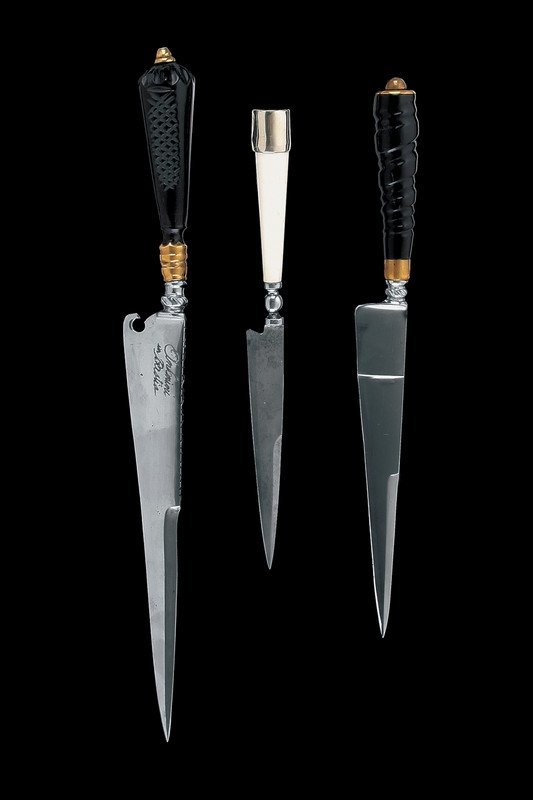 A lot of three knives: Dating: last quarter of the 20th Century Provenence: Italy Due muniti di lama marcata "Antonini in Bastia" e di impugnatura scolpita e fornimenti in ottone, uno di questo con intagli al dorso. L'ultim