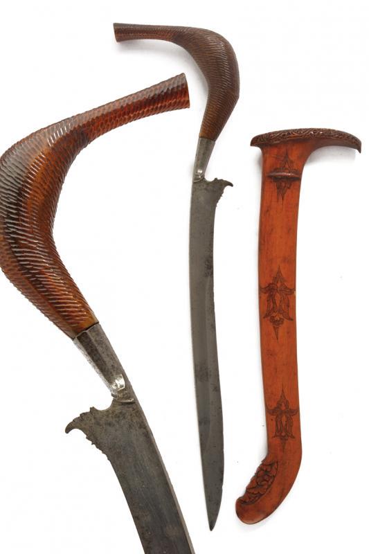Rencong: dating: circa 1900 provenance: Sumatra, Long, slightly curved, single-edged blade, base chiselled with a curl and faceted knot. Horn, checkered grip of a typical shape. Wooden scabbard, embossed and e
