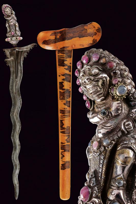 A fine kris: dating: circa 1900 provenance: Bali, Undulated double-edged blade, in fine pamor, with chiselled and grooved base. Ukiran covered with silver foil, portraying a deity, richly engraved and decorated wi