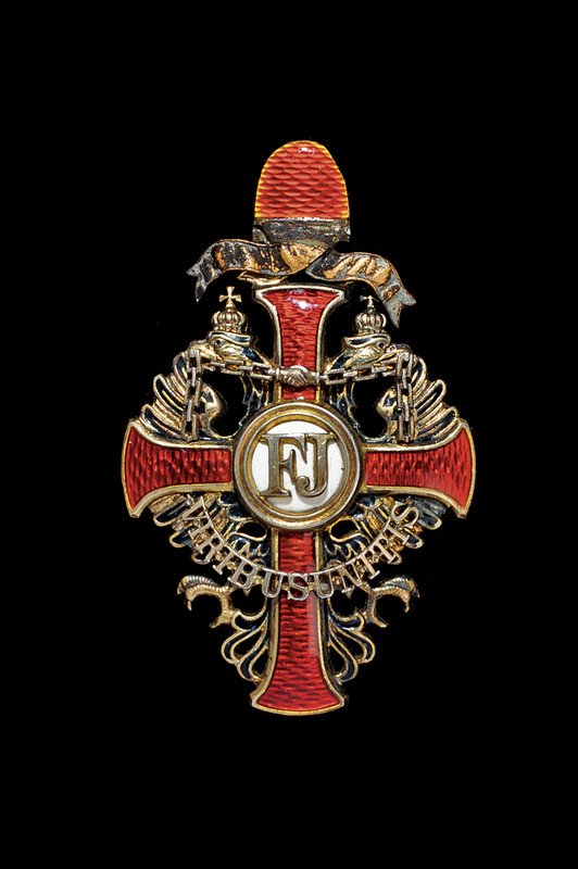 Order of Franz Joseph: dating: first quarter of the 20th Century provenence: Austria An officer's cross. Gilded and enameled silver. Missing crown. Marked on the pin's back side.