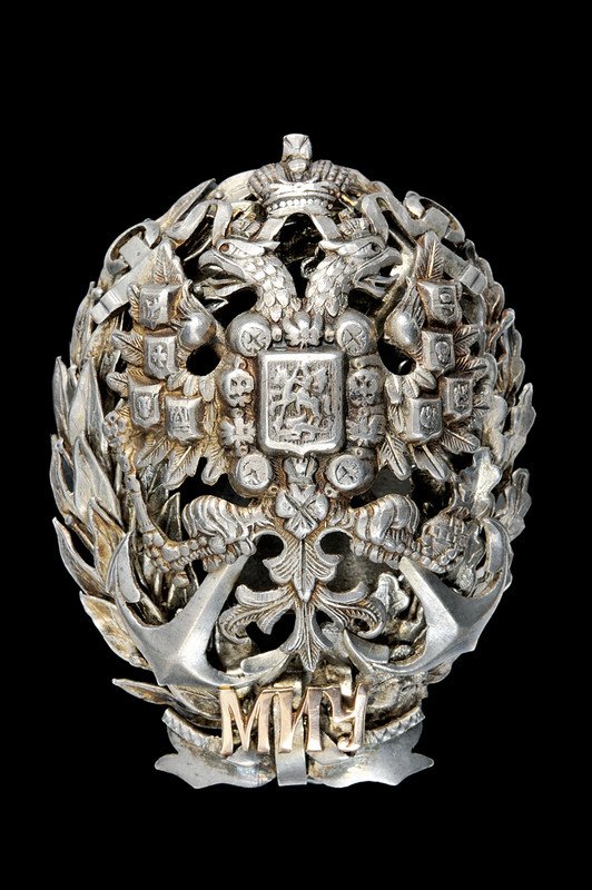A naval school zarist badge: dating: late 19th Century provenance: Russia In argento, recante l'aquila bicipite fra fronde di quercia e allori su àncora, in basso tre iniziali in oro giallo; vite e ordine punzonati. condition re