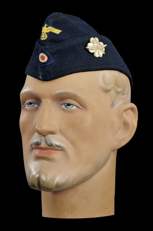 A navy trooper's beret: dating: second quarter of the 20th Century provenance: Germany In panno blu con coccarda e aquila intessuta; sul fianco spilla con sottomarino su fiore; foderata. condition report: good