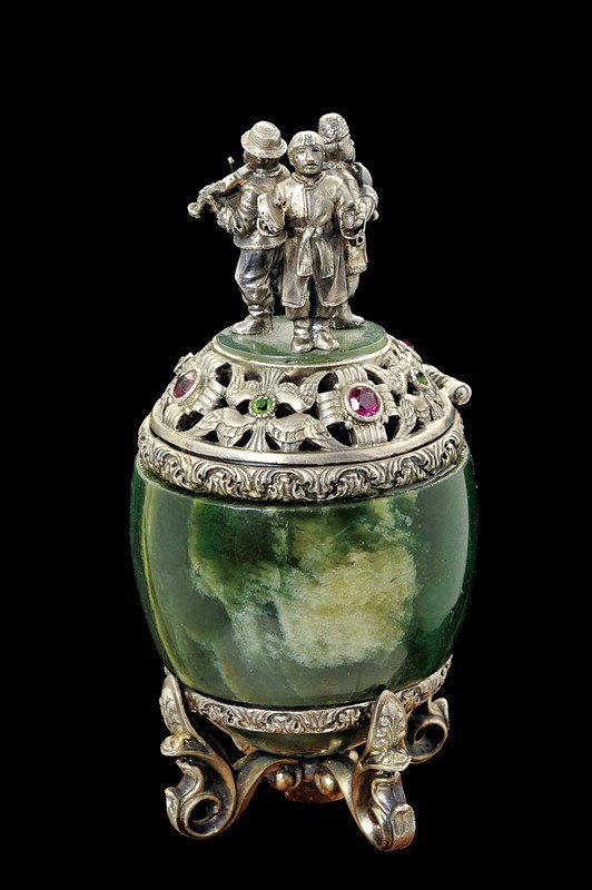 A silver mounted stone egg by Grachev: dating: provenance: Bowenite body with partially pierced, silver mounts, the musicians in the round on the cover, rubies and emeralds on the frame. On four pierced legs. In the inside the stamp "GRACH