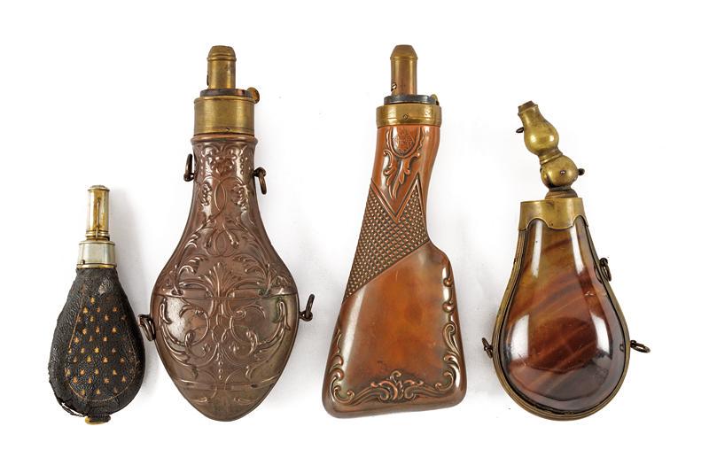 A lot of four fine powder flasks: dating: 19th Century provenance: Europe, Two made of copper with brass adjustable fuse, one shaped as a rifle butt signed 'DIXON', one made of cow horn (a crack) with brass mounts, folding fuse, one o