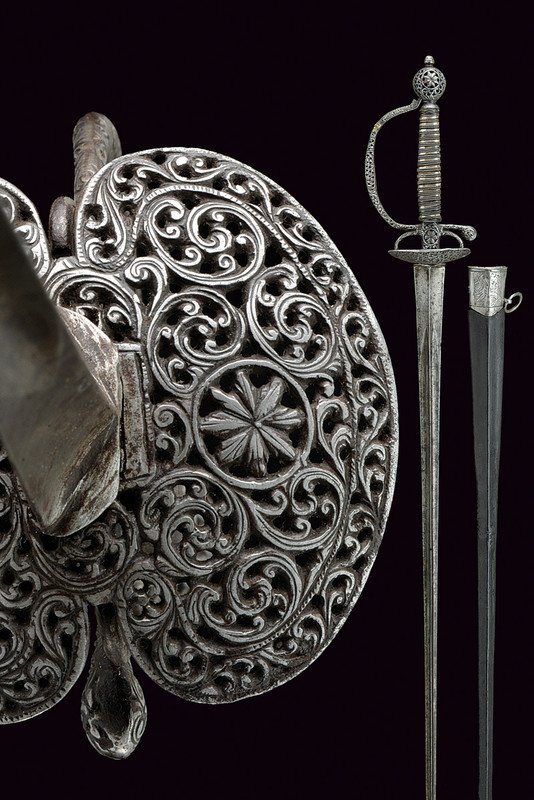 A court small-sword: dating: 18th Century provenance: France Straight, colichemarde blade of triangular section with hollow faces; iron hilt; two valves sword-shell pierced with racemes, the quillon chiselled en suite and