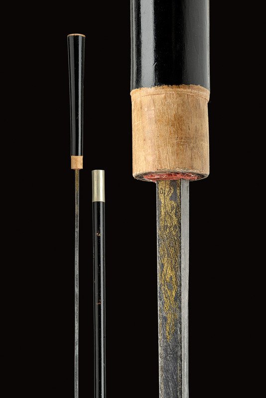 A stick sword: dating: 19th Century provenance: Italy Iron blade of square section, at the base remains of gilt engravings on finished ground; black lacquered, wooden grip and scabbard with silver band. dimensions: