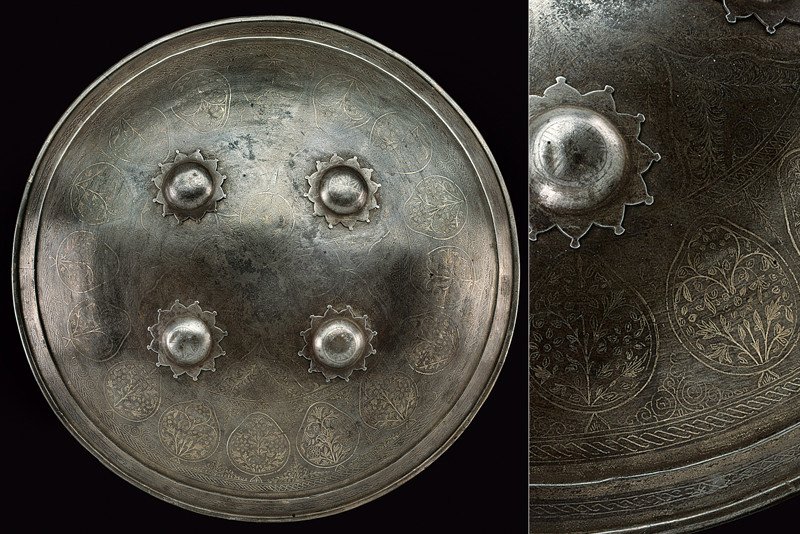 A silver decorated sipar: dating: mid-19th Century provenance: Turkey Circular, convex, iron shield provided with four studs with star-shaped base; the surface decorated with silver floral and geometrical motifs. At the inside