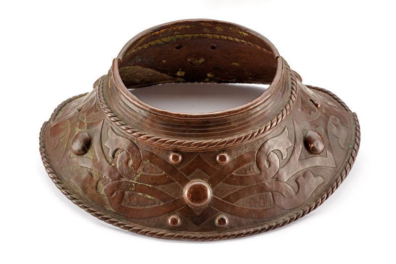 A copper gorget: dating: 19th Century provenance: Italy In two parts, with closing device; decorated with woven bands and hemmed border. dimensions: dimensions 33.5 x 28 cm.