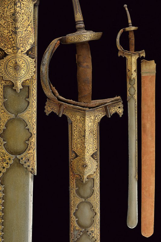 A rare and beautiful khanda: dating: early 19th Century provenance: India Wide, single -and false-edged blade, slightly wider toward the foible, of fine wootz damask, the base and the back provided with strengthening bands featur