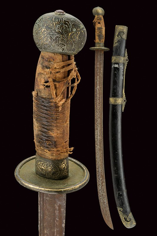Dao (sabre): dating: circa 1900 provenance: China Curved, single -and false-edged balde with double groove; brass hilt engraved with floral motifs; wooden grip with remains of fabric binding. Wooden scabbard, lacq