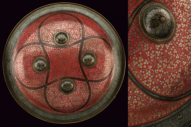 A fine Benares dhal: dating: circa 1900 provenance: India Made of brass, of circular and convex shape, provided with four studs; finely decorated with silver floral motifs on black and red ground at the surface. The borde