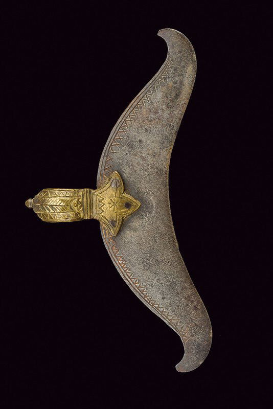 A bullova head (axe), dating: 19th Century, provenance:: A bullova head (axe), dating: 19th Century, provenance: India, dating: 19th Century, provenance: India, Iron axe with concave edge, engraved with geometrical motifs at the back; round, brass quillon b