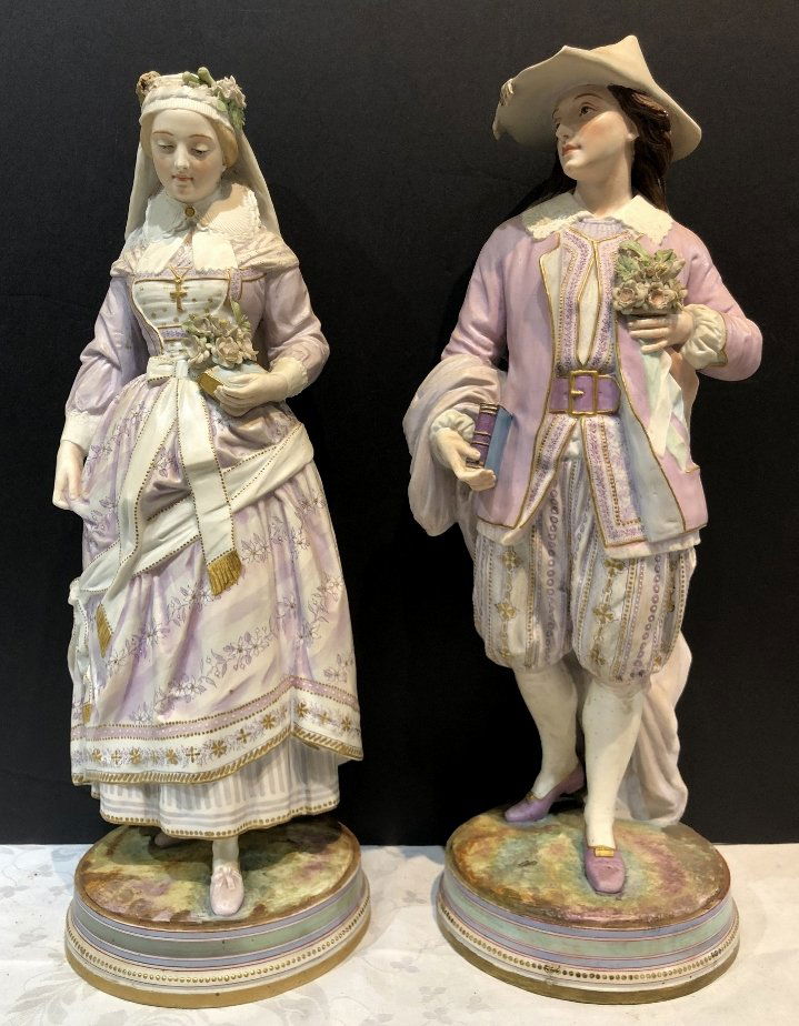 Pair of bisque Elizabethans, with books, c.1880: Pair of bisque Elizabethans, with books, c.1880.Restoration to the base on the male, probably a break across the platform that was restored about 75 years ago.18" to 19" high each.