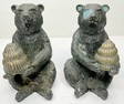 Two white metal bears with beehives