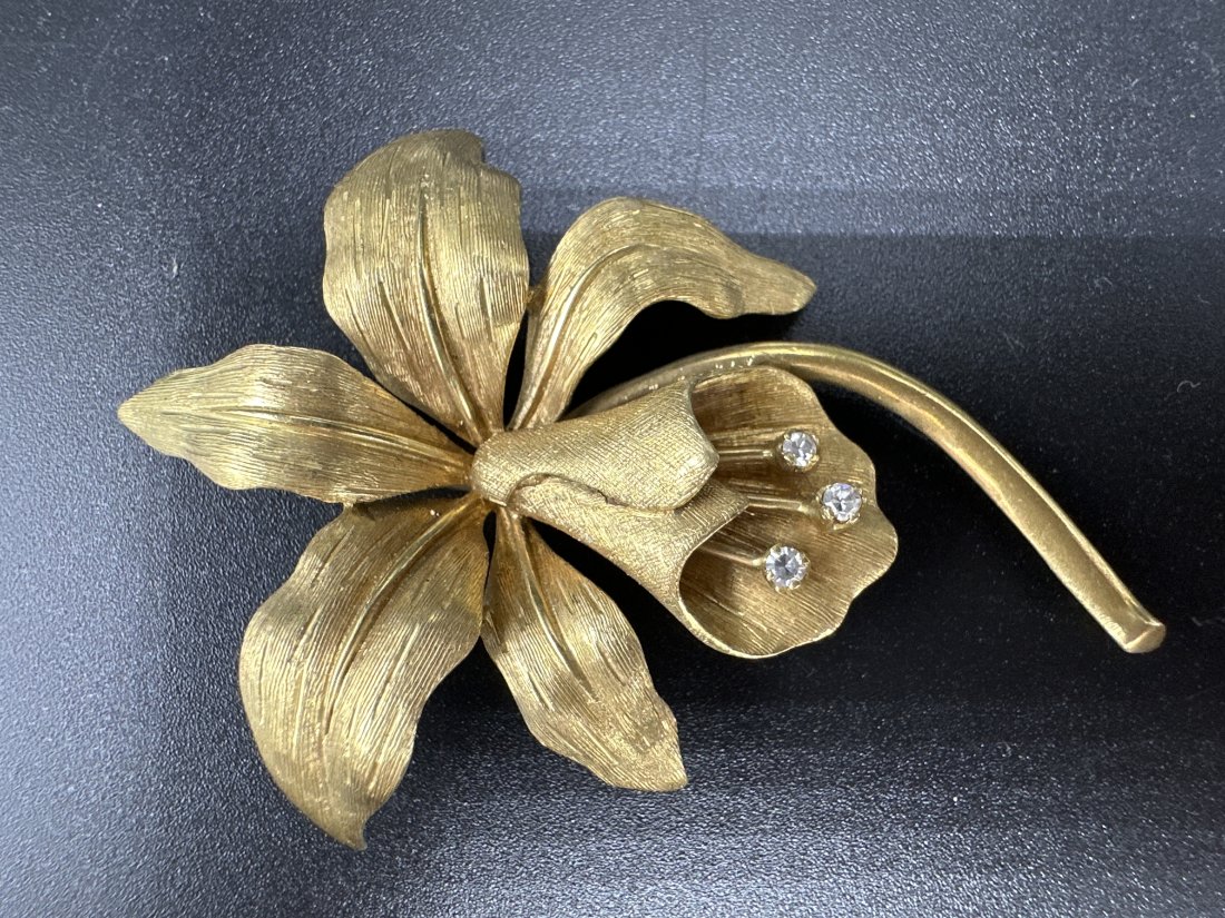 18k yellow gold diamond flower brooch, c1965: 18k yellow gold diamond flower brooch, c1965. Weight: 7 dwts. The length is 2.5" and the width is 1.75".