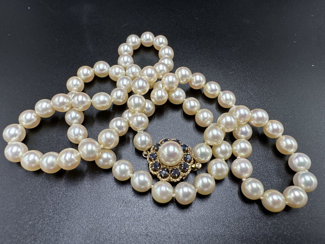 A strand cultured pearls with sapphire 14k clasp: A strand cultured pearls with sapphire 14k clasp 23" length.Stamped 14k on the clasp and guaranteed 14k gold.