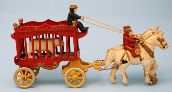 Kenton Overland Circus Wagon Cast Iron Toy: 1930s Kenton Circus Wagon With Bear. Cast iron. Cage measures 7" W x 3-3/4" D x 6" T. Horses Drawn Cart measures 10-1/4" L x 4" D x 5" T. Includes Driver, 2 Horse Riders, and a Bear,