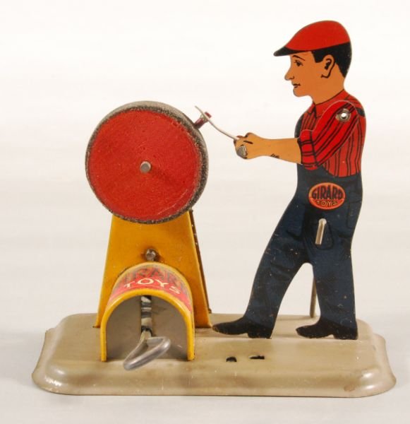 Girard Toys Man & Grinding Wheel Wind-Up Tin Toy: Depicts man sharpening tool on grinding wheel. Does not operate when wound, but all gears & wheels turn. Measures 4-1/2" L x 3" D x 4-1/2" H. (P978.101.551)