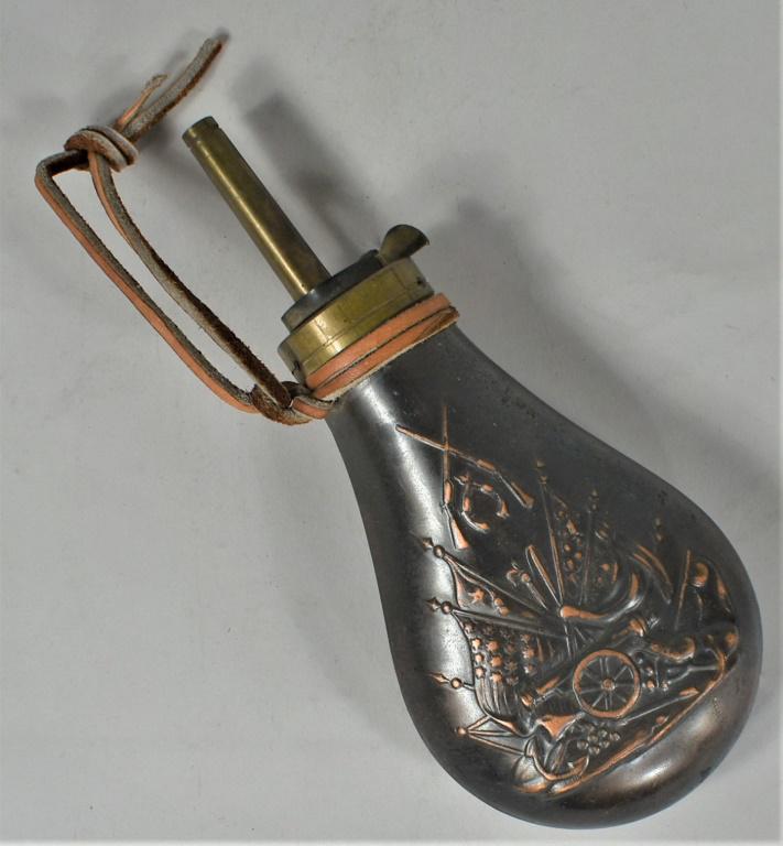 Copper Flashed Embossed Black Powder Flask: Copper Flashed Embossed Black Powder Flask. Cannon, flag and gun motif. 7 1/2 inches tall overall.