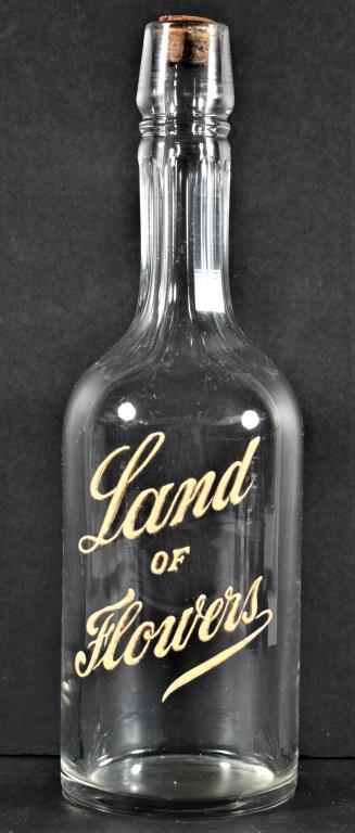 Enamel Label Back Bar Bottle for Land of Flowers Whiskey: Enamel Label Back Bar Bottle for Land of Flowers Whiskey. No chips or cracks. 11 1/4 inches tall.