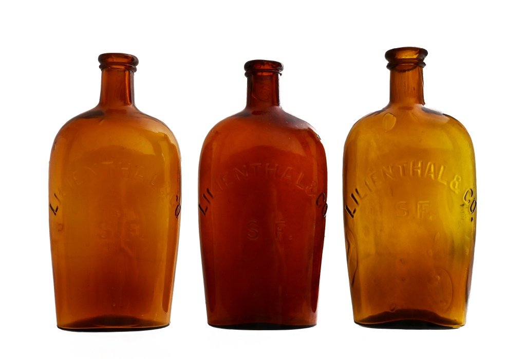 Embossed Amber Whiskey Flask Style Bottles: Embossed Amber Whiskey Flask Style Bottles for Lilienthal & Co. San Francisco. A couple of lip chips. Approx. 8 1/2 inches tall.
