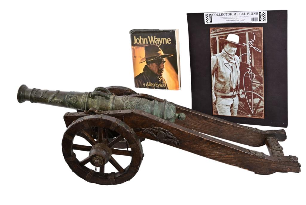 John Wayne Cannon Given to Robert Evans: Spanish cannon given as gift from John Wayne to Robert Evans after the filming of the motion picture "True Grit". 44" x 16" x 16". Age unknown. Shows age & a great patina. Likely a signal cannon, or o
