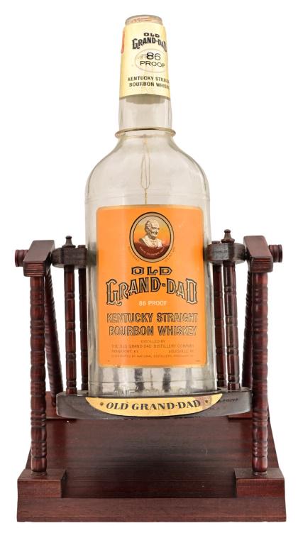 100 Proof Old Grand-Dad Counter Top Display: 1960's 1 Gallon 100 Proof Old Grand-Dad Counter Top Display. Bottle sits on swinging wood display rack. 22" x 12" x 10.5".