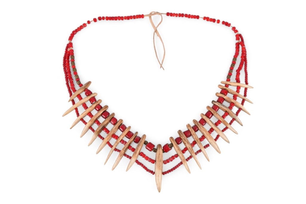 Wind River Indian Reservation Carved Bone Necklace: Carved bone to resemble Grizzly bear teeth (no grizzly remain on the Reservation). Red white heart trade beads. Measures approximately 3" x 28"