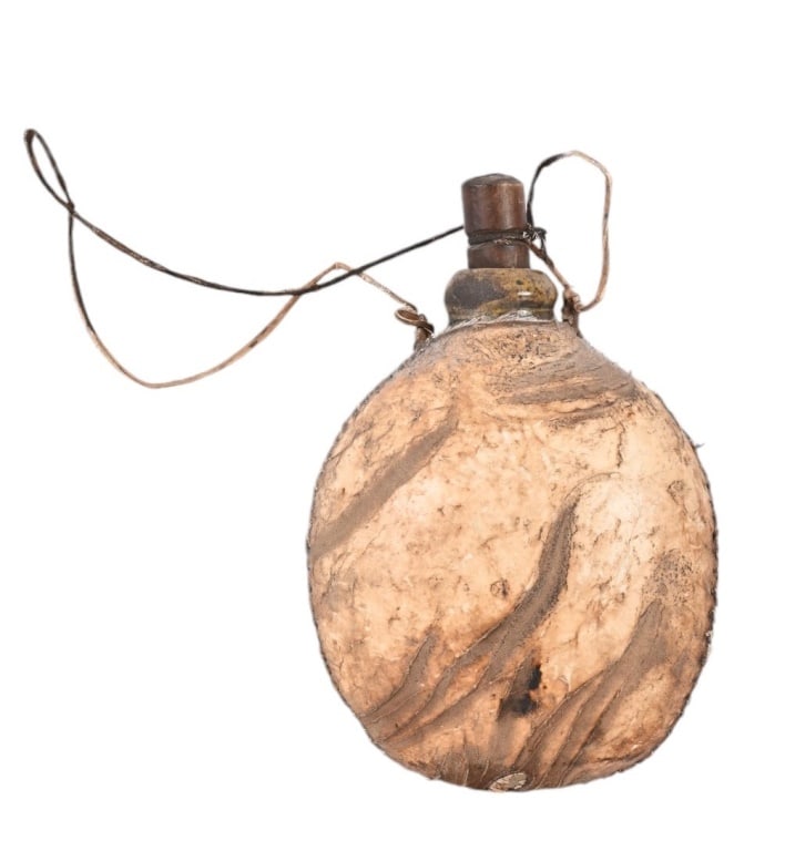 Indian Hide Wrapped Ceramic Water Canteen: Glazed ceramic canteen with wood stopper, wrapped in deerskin and sinew sewn. Measures 3" x 5" x 7.5"