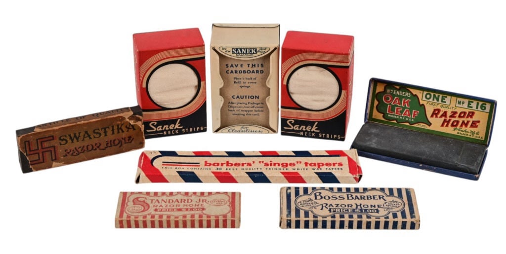 Collection of Vintage Barbershop Items: Sanek neck strips, sanek neck strip dispenser, barbers "singe" tapers, Swastika Razor Hone, Oak Leaf Razor Hone, Boss Barber Razor Hone, and Standard Jr. Razor Hone.