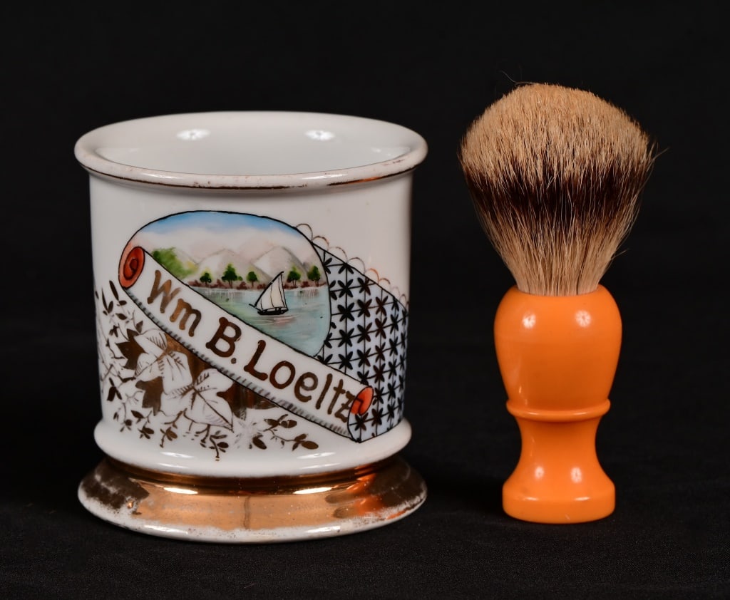 Antique Occupational Shaving Mug With Brush: With image of Mountains and Sail Boat on the water. Wm B. Loeltz in gold lettering. Comes with Made Rite badger hair shaving brush.