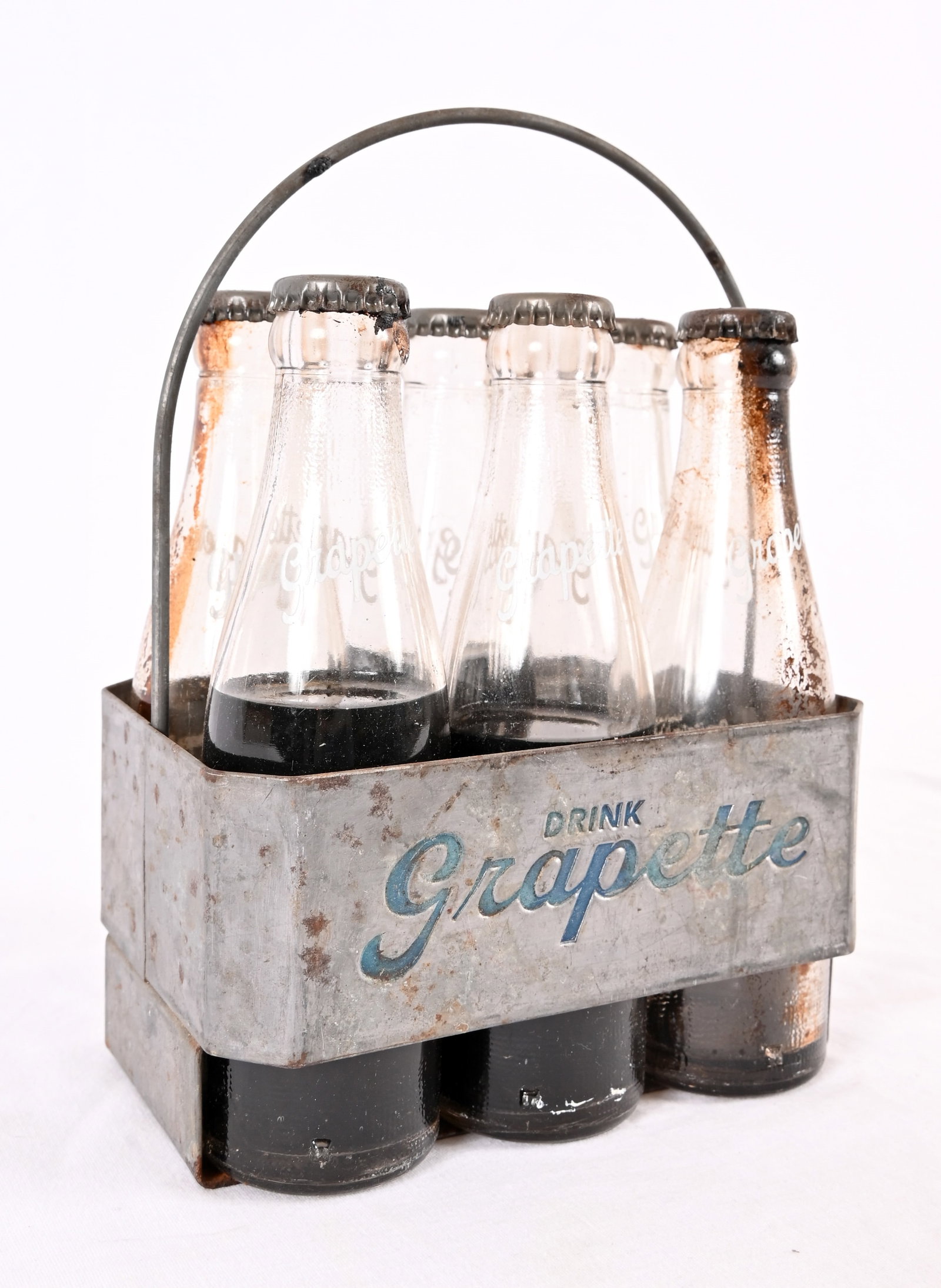 Vintage Grapette Soda Carrier & Bottles: 4 1/2 " x 7" x 9" metal carrier with 6 Grapette bottles.