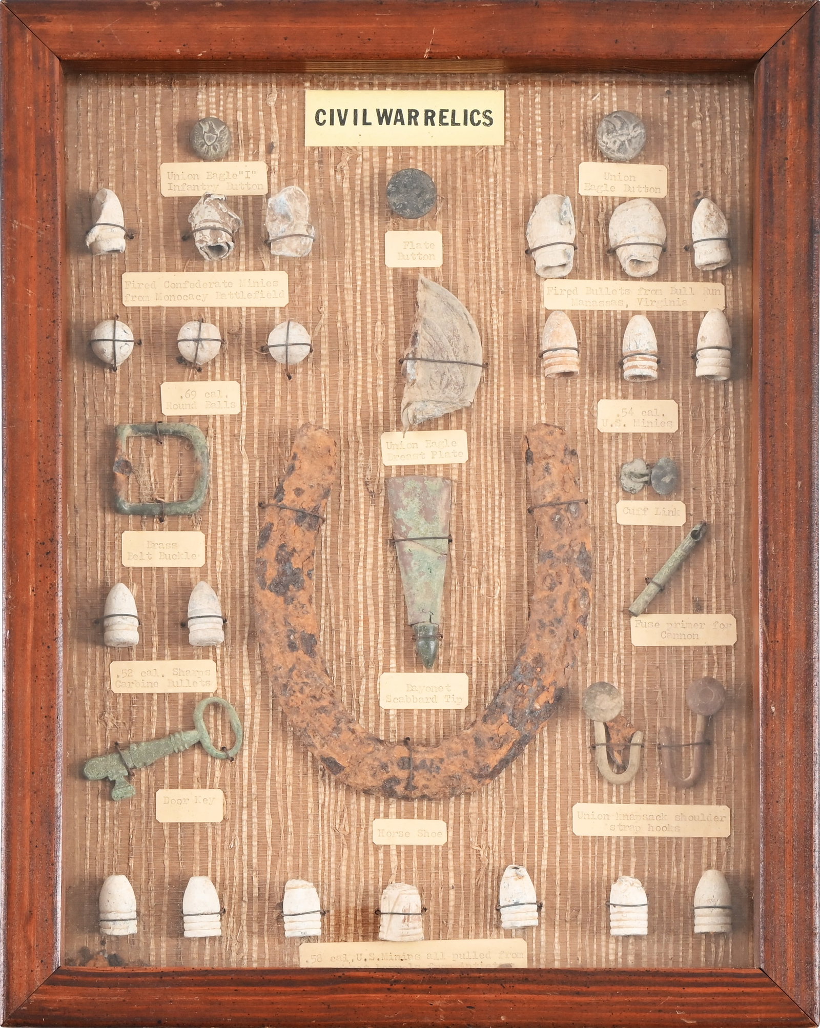 Collection Of Civil War Relics: Includes bullets, buttons, belt buckle, horseshoe, breast plate, cuff link door key and cannon fuse primer. In display case that measures 12 1/4" x 15 1/2" x 1 3/4".